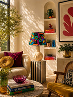 Living room with colorful decor, books, and a lamp.