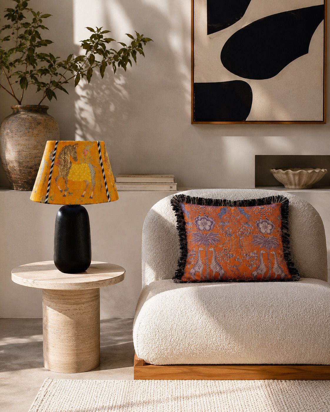 Living room with a white armchair, decorative pillow, side table with lamp, and abstract art on the wall.
