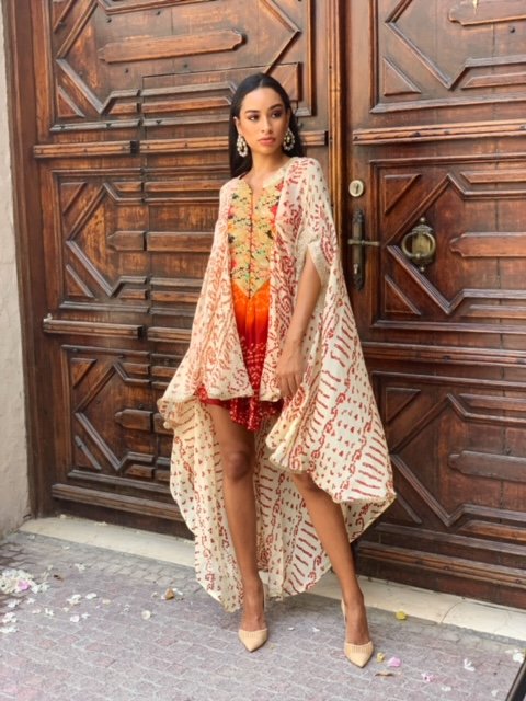 Woman in a floral dress standing in front of a wooden door